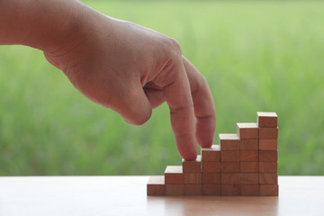 Hand holding yellow paper boat on the lake