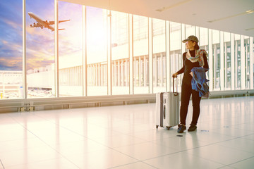 Fototapeta premium single woman and traveling luggage standing in airport terminal building