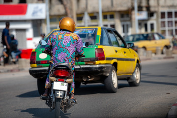 Motorbike in traffic of Cotonou, Benin. The people of Benin in daily life, lifestyle of West Africa. Fashion of Benin, West-Africa.