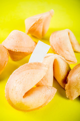 Chinese fortune cookie with prediction on bright yellow background top view copy space