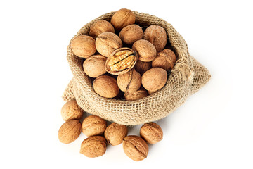Whole walnuts (in shell) in burlap sack isolated on white background