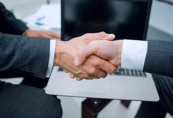 close up.handshake business partners over the Desk.