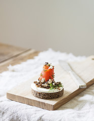 Danish smorrebrod sandwich with salmon and feta cheese on a wooden Board. Concept for restaurant and cafe.