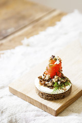 Danish smorrebrod sandwich with salmon and feta cheese on a wooden Board. Concept for restaurant and cafe.