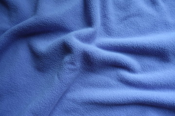 Thick blue fleece fabric in soft folds