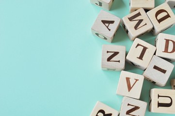 Wooden blocks with letters on mint background with copy space.