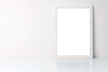 Photo of a white mockup frame on white blank wall copy space background on a white desk