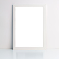 Photo of a white mockup frame on a white desk or shelf