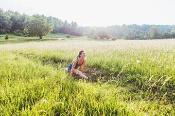 Young woman doing exercise in the nature at sunset