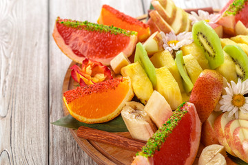 Fresh fruits in plate on wooden table