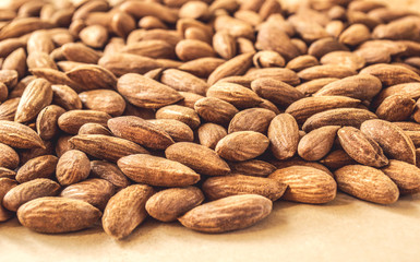 Many almond nuts on wooden board, close-up