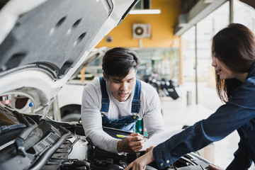 Reliable auto mechanic talking to a female customer the engine error in a modern automobile repair shop