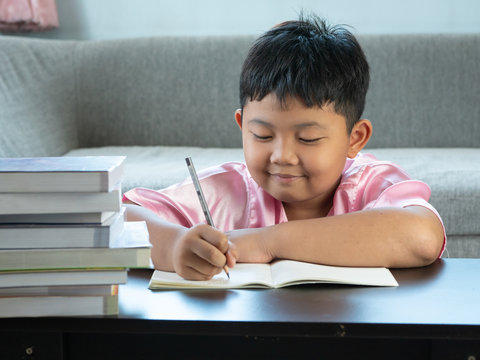 Cute Asian Boy Write Homework At Home. Education Concept