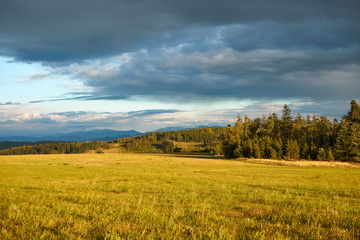Fototapeta na wymiar Czech landscape at sunset, Beskydy mountain in the distance, dark clouds on the sky