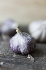 Close-up view of fresh raw garlic bulbs on rustic wooden background