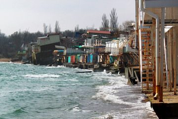 Coastal erosion - houses built on weak clay soil slide down to the sea and collapse near Odessa,...