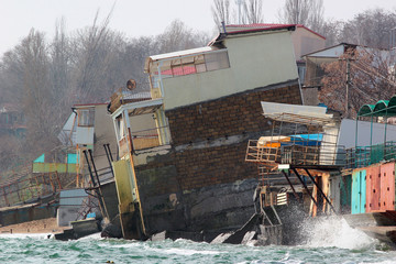 Coastal erosion - houses built on weak clay soil slide down to the sea and collapse near Odessa,...