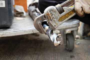 Work with a wrench holding a drill bit.