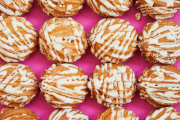 A number of brown donuts on a lilac background. 