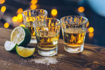 Shot of tequila with lime and salt on bokeh background - obrazy, fototapety, plakaty