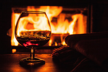 glass of cognac in front of fireplace