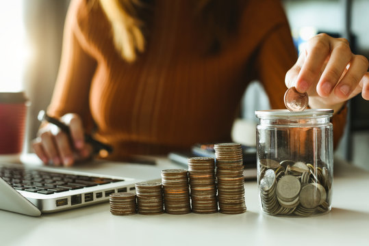 businessman holding coins putting in glass with using smartphone and calculator to calculate  concept saving money for finance accounting