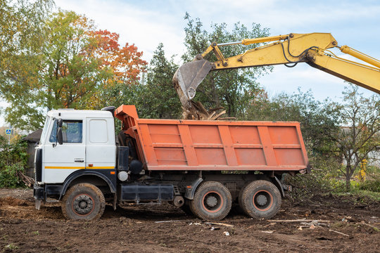 Excavator Bucket Loading Construction Debris Into Truck Body Closeup