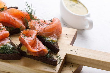 Homemade gravlax, smoked salmon with mustard sauce and dill  on toasted rye bread