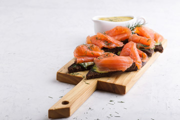 Homemade gravlax, smoked salmon with mustard sauce and dill  on toasted rye bread