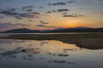 Fototapeta na wymiar Colorful, spectacular sunset over Balkan mountain and artificial lake Jrebchevo. Last rays of light. Landscape, background.