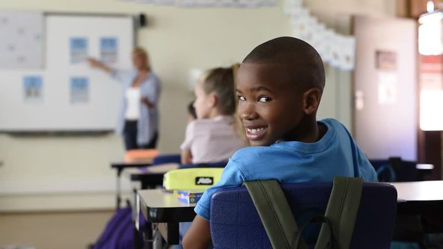 Portrait of proud african school boy looking at camera in classroom