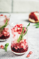 Rosemary pomegranate champagne cocktail with ice cubes. Selective focus, space for text.