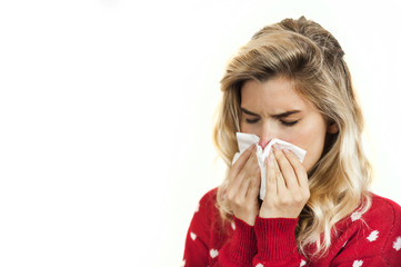 Symptoms of flu or allergies. Strong young European woman with fever, sneezing in a tissue,...