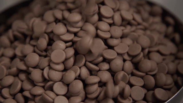 Pouring chocolate into bowl for tempering. Technology of production of sweets in factory