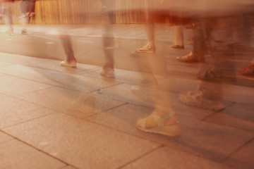 Legs of people in motion on the road as a background