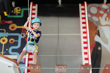 Young child crossing a bridge at the high rope course