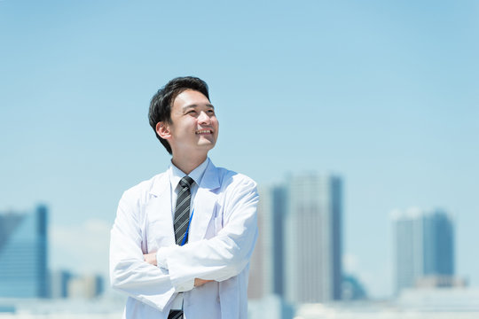 腕組みをする白衣の男男性