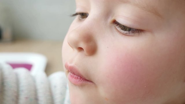 Little kid girl eating drinking a foam from cappuccino of mother cup