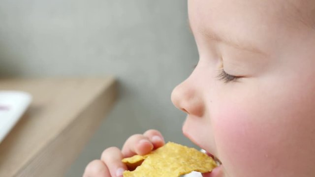 Child kid eats potato snacks with hands in fast food restaurant