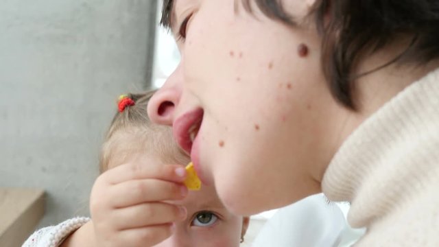Child kid with mom eating potato snacks having fun kiss in fast food