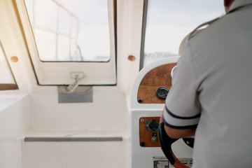Naklejka na ściany i meble Hand of captain on the steering wheel of the motorboat in the blue ocean during the fishery day. Success fishing concept. Ocean yacht
