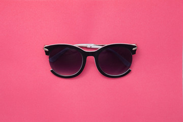 Sunglasses for women on a pink background. Square summer texture.