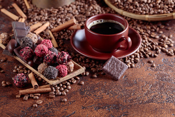 Various chocolates  and cup of black coffee.
