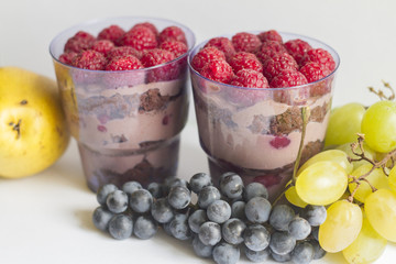 a hand with a beautiful manicure holds a cake in a Cup with berries and chocolate