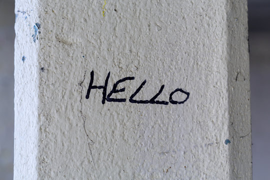 The word 'Hello' written in felt tip pen on an old pillar.