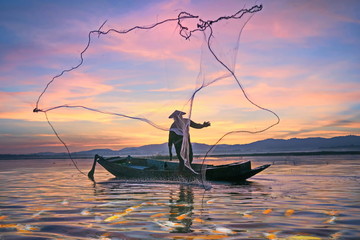 Fishermen fishing in the early morning golden light.Fishermen on a fishing boat