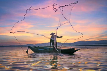 Foto op Canvas Fishermen fishing in the early morning golden light.Fishermen on a fishing boat © oneSHUTTER oneMEMORY