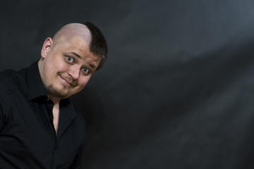 Obraz premium Punk. Portrait on a dark background. The expression is ironic and teasing. copy space