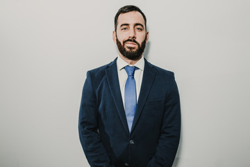 Young businessman, dressed in suit and tie placed on a neutral background. Different facial gestures, expressing emotions. Lifestyle.