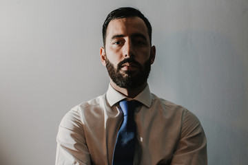Young businessman, dressed in suit and tie placed on a neutral background. Different facial gestures, expressing emotions. Lifestyle.